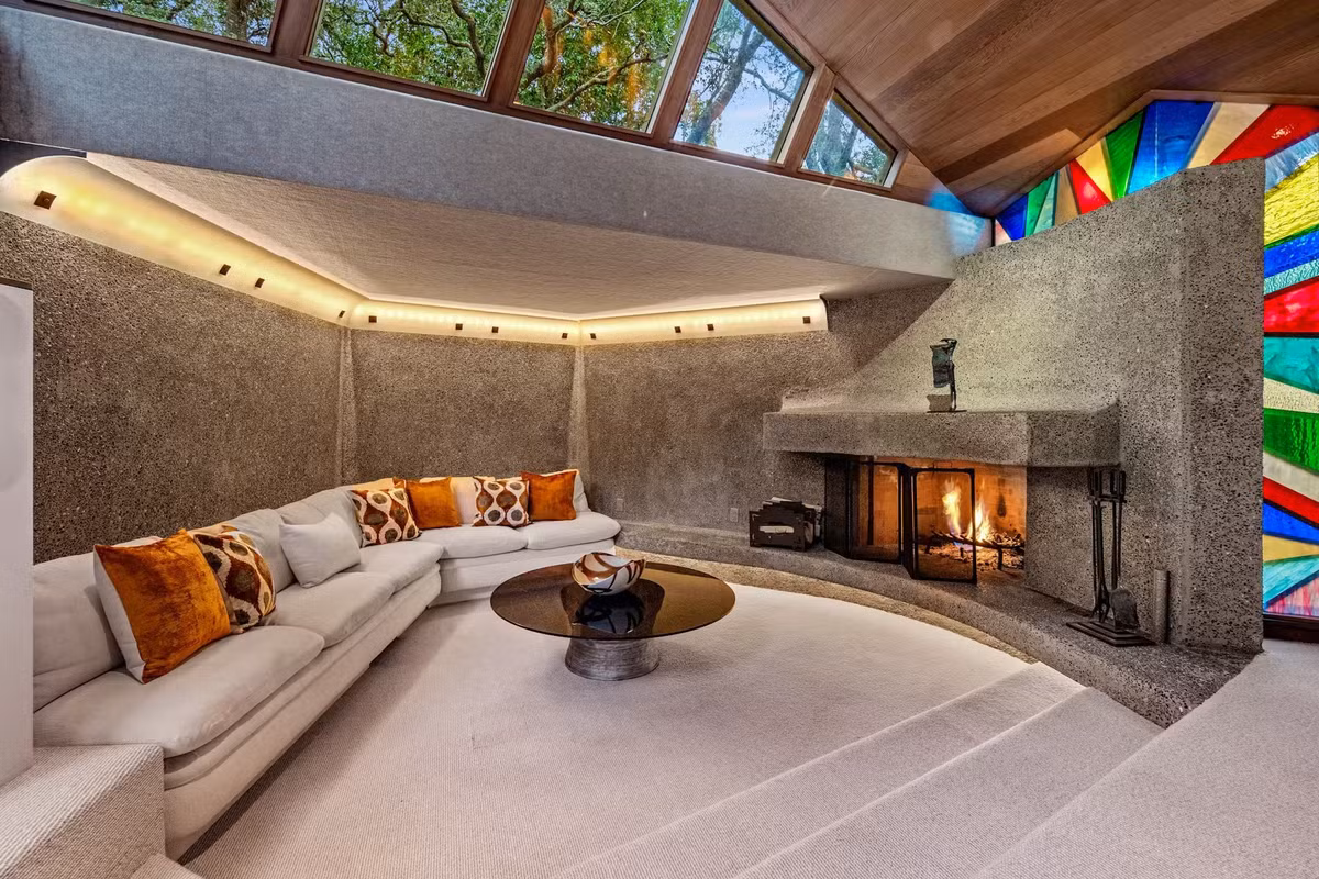 Các điểm nhấn bằng kính màu và lò sưởi nguyên khối tô điểm cho khu vực sinh hoạt rộng lớn.