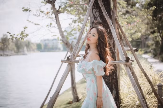 Nữ MC sinh năm 1985 đẹp mong manh, quyến rũ trong chiếc váy voan hoa màu xanh mint mát mắt, với điểm nhấn là đường bèo nhún vừa phải ngang vai. Vân Hugo chọn lối trang điểm tone cam - xanh, mái tóc uốn xoăn nhẹ phù hợp với trang phục.