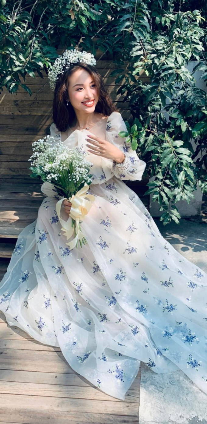 Vân Hugo hóa “công chúa tóc mây” khi diện chiếc váy bồng bềnh, đặc biệt là phần tay được đắp ren tỉ mỉ tạo độ phồng cho tay áo. Chiếc váy trắng thướt tha điểm hoa tím mang lại cho nữ MC vẻ dễ thương vượt xa tuổi thật, kết hợp ăn ý cùng mái tóc dài và hoa baby đội đầu.