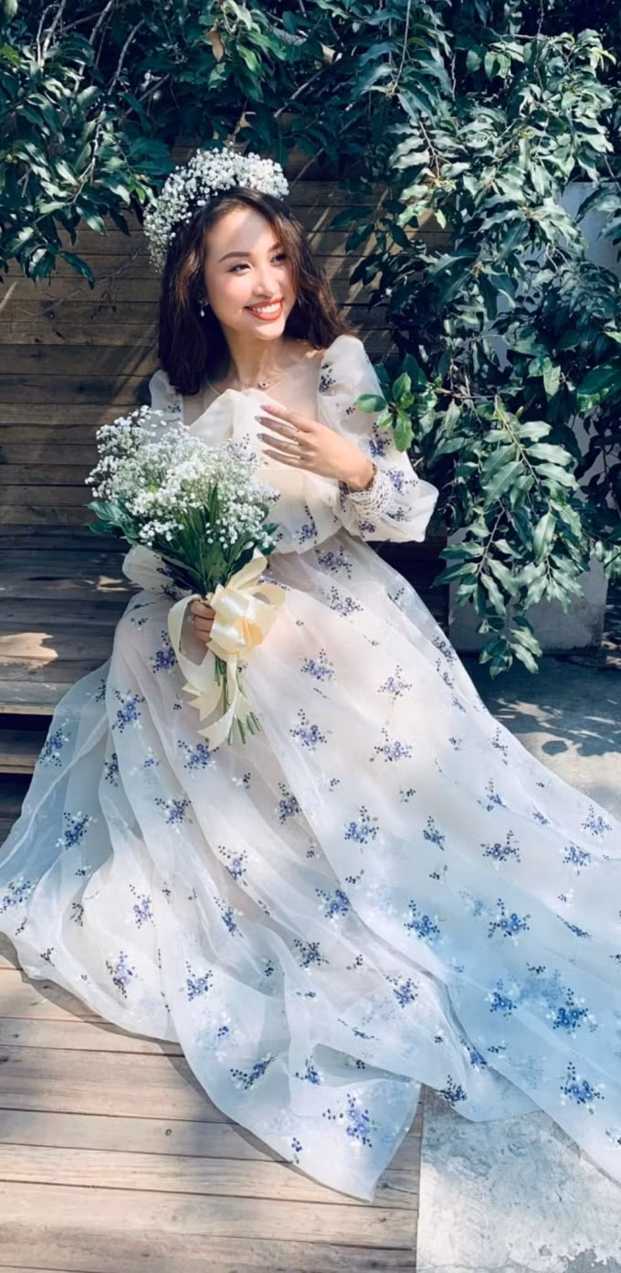 Vân Hugo hóa “công chúa tóc mây” khi diện chiếc váy bồng bềnh, đặc biệt là phần tay được đắp ren tỉ mỉ tạo độ phồng cho tay áo. Chiếc váy trắng thướt tha điểm hoa tím mang lại cho nữ MC vẻ dễ thương vượt xa tuổi thật, kết hợp ăn ý cùng mái tóc dài và hoa baby đội đầu.