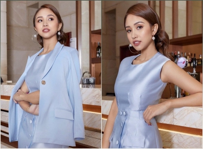 Vân Hugo tạo dáng sang chảnh khi diện váy tafta màu xanh bóng với hàng cúc bọc chạy dọc thân váy, khoác cùng áo blazer đồng màu. Nữ MC chọn lối trang điểm nâu trầm, mix cùng khuyên tai tròn bản to.