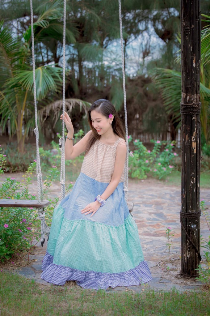 Vân Hugo dễ thương trong chiếc váy xếp tầng màu sắc, với tone xanh làm chủ đạo cùng họa tiết caro, mix cùng dây vải đeo tay. Bí quyết giúp cô giữ được vẻ trẻ trung là việc lựa chọn các mẫu váy liền họa tiết tối giản, không quá cầu kỳ. Nhìn hình ảnh này, ít ai nghĩ rằng cô đã bước sang tuổi 37.