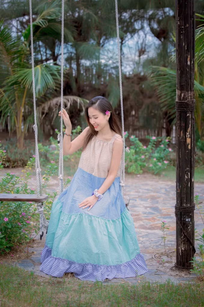 Vân Hugo dễ thương trong chiếc váy xếp tầng màu sắc, với tone xanh làm chủ đạo cùng họa tiết caro, mix cùng dây vải đeo tay. Bí quyết giúp cô giữ được vẻ trẻ trung là việc lựa chọn các mẫu váy liền họa tiết tối giản, không quá cầu kỳ. Nhìn hình ảnh này, ít ai nghĩ rằng cô đã bước sang tuổi 37.