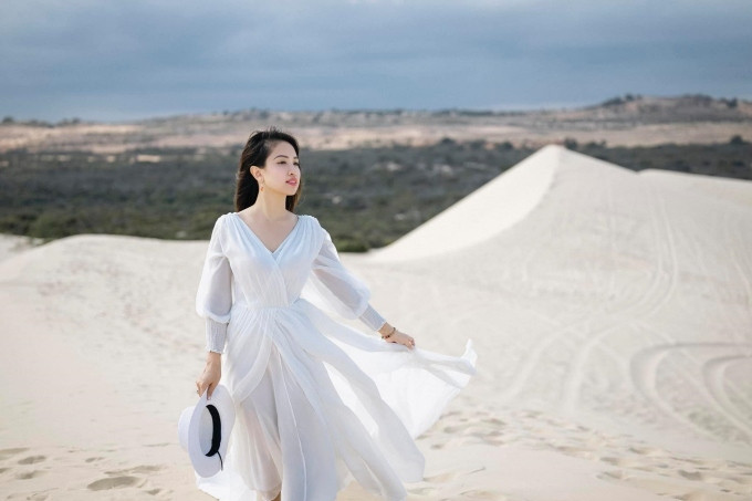 Thanh Vân dịu dàng, mong manh trong chiếc váy voan lụa màu trắng nhiều lớp, với cánh tay bồng và phần cổ V thanh thoát. Cùng với thiết kế dáng dài trên chất liệu mỏng nhẹ, các lớp tà váy được xếp chồng khéo léo giúp nữ MC – diễn viên càng đẹp bay bổng, phù hợp với khung cảnh thiên nhiên.