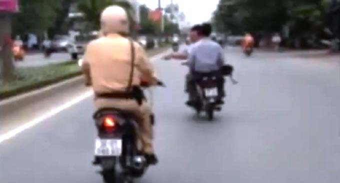 Chiến sĩ CSGT vừa điều khiển xe máy...