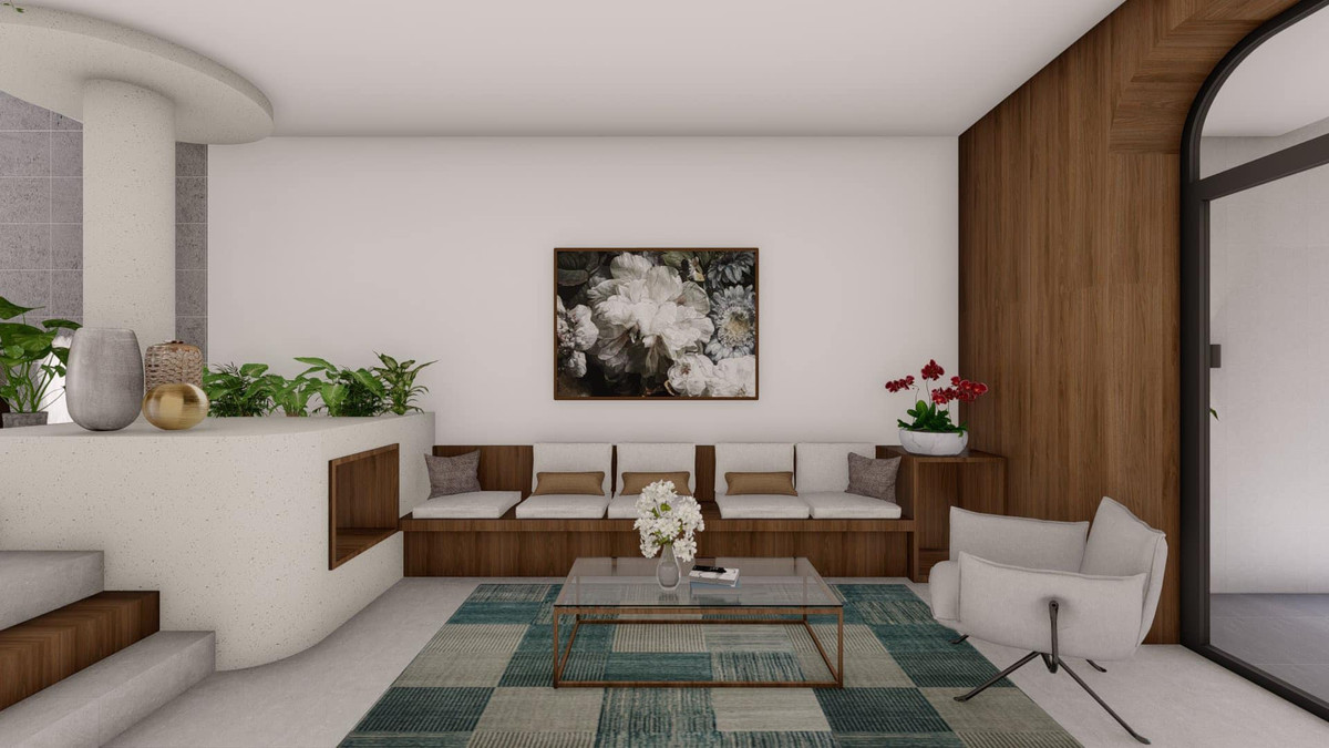 Nhà nhỏ nên kiến trúc sư dùng gam màu sáng là chính để mở rộng diện tích về mặt thị giác. Phía trong bếp có nền cao hơn phòng khách nhằm phân biệt hai không gian. Một bậc tam cấp ốp gỗ có ý nghĩa trong việc đảm bảo an toàn khi sử dụng, gia chủ sẽ không bị bước hụt. Ghế sofa văng đơn giản là hệ hộc tủ dài và rộng, cho cả nhà thoải mái ngồi xem phim, quây quần bên nhau.