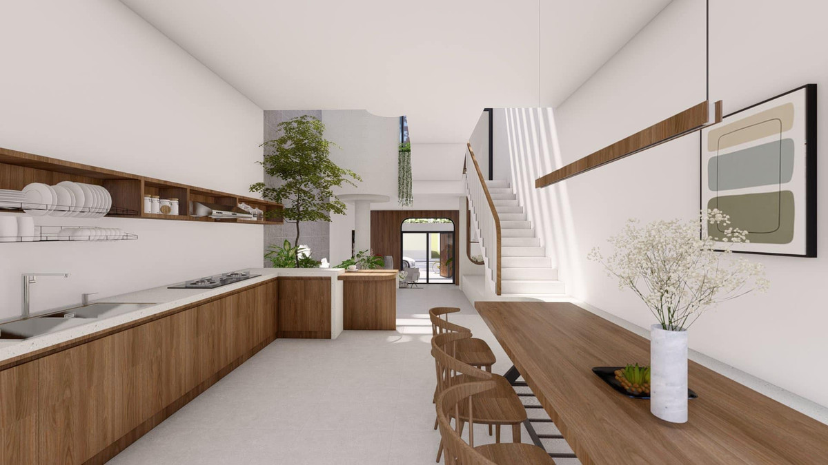 Khu vực bếp chạy dài, dọc nhà tạo độ thoáng và có lối đi lại rộng rãi. Bàn ăn kết nối với vườn cây nhỏ, chan hòa ánh sáng. Do tủ bếp dài, nhiều hộc ở dưới nên nhóm chỉ làm kệ nhỏ, đơn giản, cho bếp trông thật nhẹ nhàng.