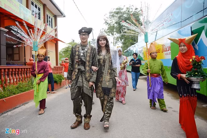 Đoàn rước dâu gồm những thanh niên trong trang phục truyền thống bưng cờ hoa, chiêng trống đưa cặp đôi từ đầu làng vào toà nhà chính. "Vợ" của JVevermind trong đám cưới là một nữ diễn viên, ca sĩ trẻ người Thái Lan - Ying Kanyapatch. Cô cũng từng đoạt giải nhất Miss Teen Thailand 2007.