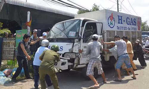 Cảnh sát giao thông cùng người dân đẩy xe tải vào lề đường.