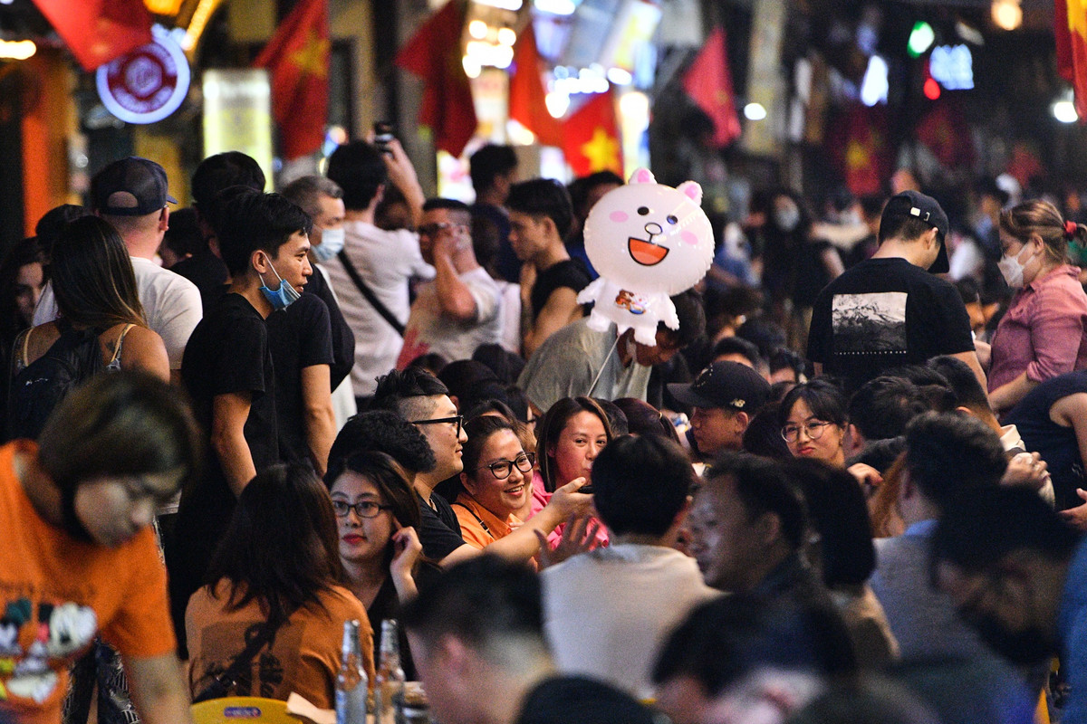 Hàng quán kê bàn ghế tràn xuống lòng đường, chỉ để lại một lối đi hẹp ở giữa.