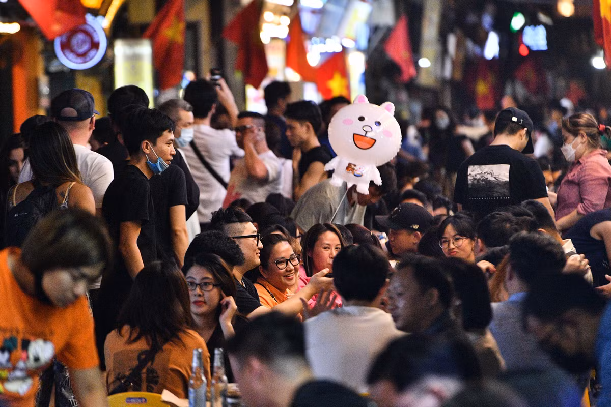 Hàng quán kê bàn ghế tràn xuống lòng đường, chỉ để lại một lối đi hẹp ở giữa.