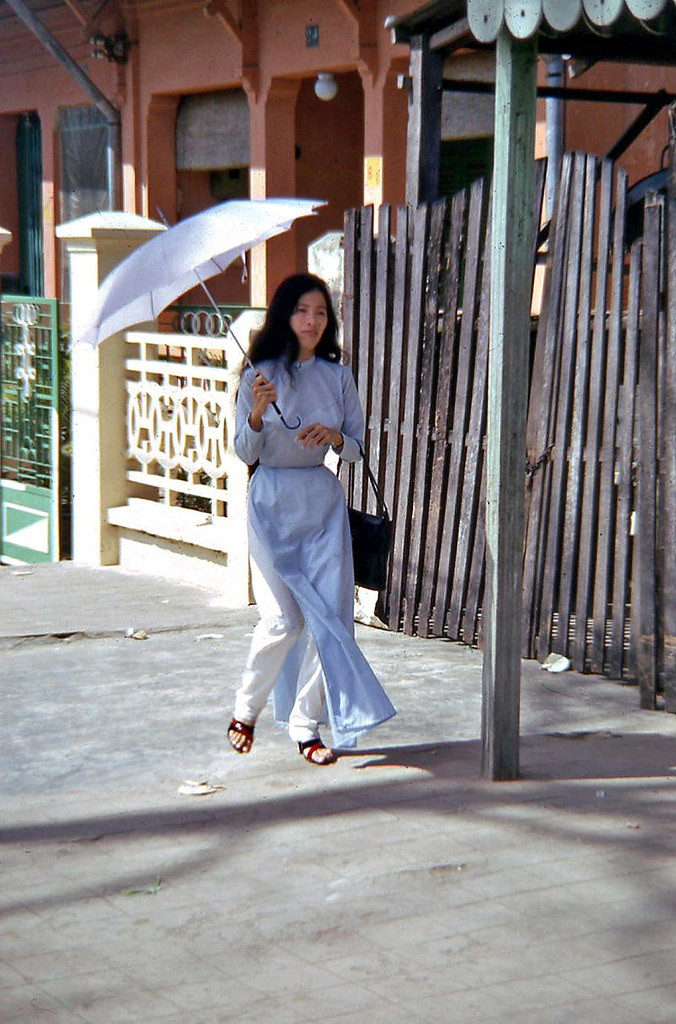 Thiếu nữ áo dài che ô đi trên hè phố Phan Đình Phùng. Ảnh: Waynecam.