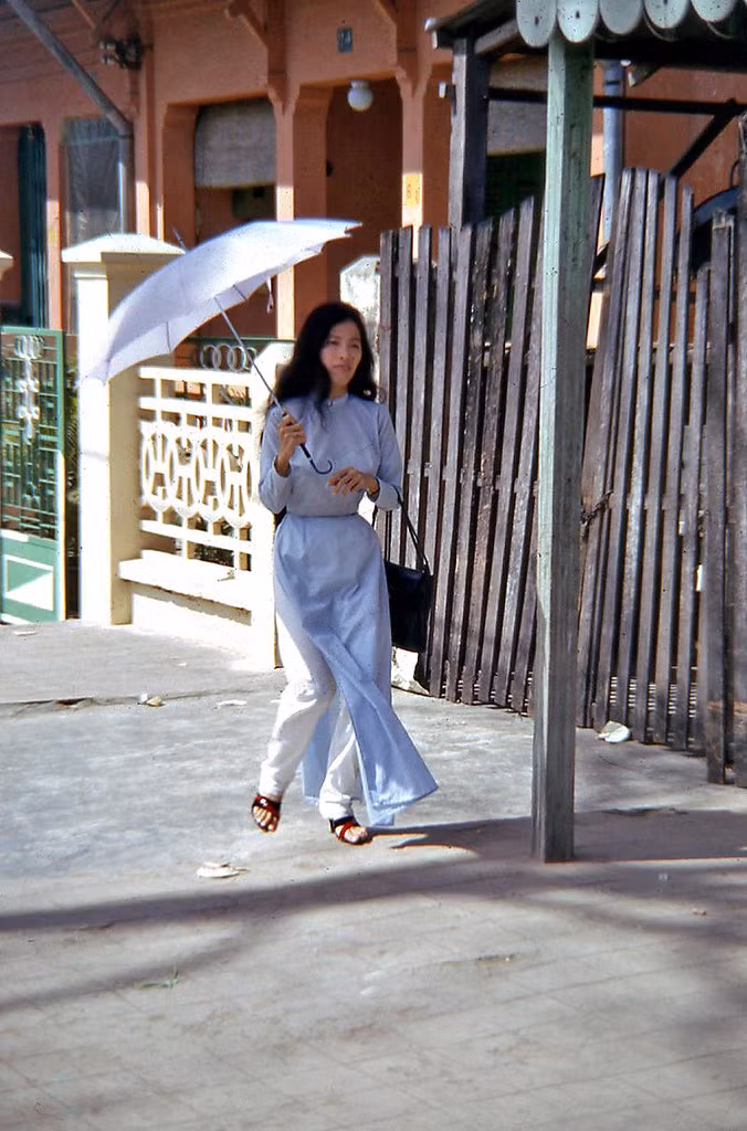 Thiếu nữ áo dài che ô đi trên hè phố Phan Đình Phùng. Ảnh: Waynecam.