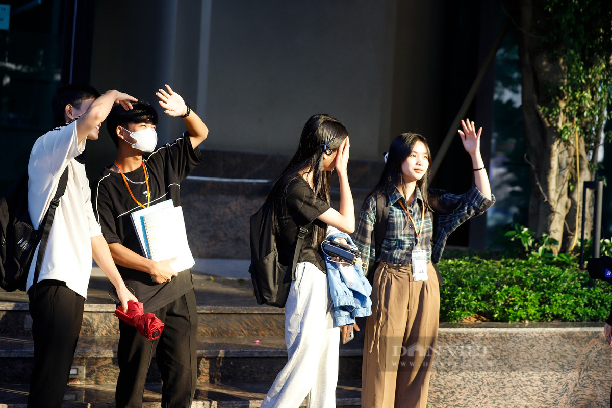 Một nhóm người đi bên cạnh tòa nhà bị phản chiếu gần QMS Top Tower đã phải lấy tay che mặt khi đi ngang qua.