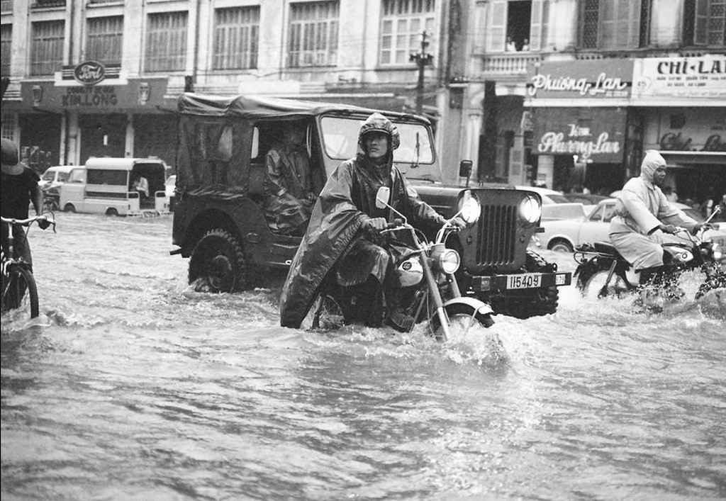 Dù nước ngập, vẫn có rất nhiều người qua lại trên đại lộ Lê Lợi vì đây là trục đường chính của quận 1. Ảnh: Eddie Adams.