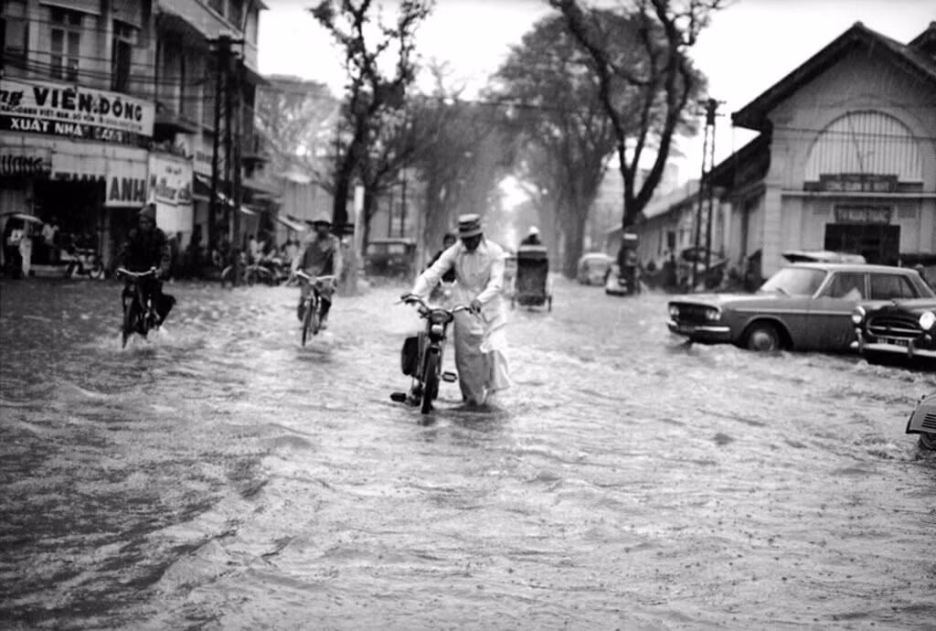 Chiếc xe không chạy nổi, một người đàn ông phải dắt xe qua ngã tư Lê Lợi - Parteur. Ảnh: Eddie Adams.