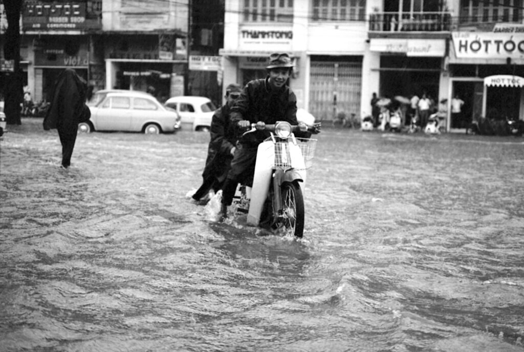 Chàng trai vượt biển nước trên đại lộ Lê Lợi. Ảnh: Eddie Adams.