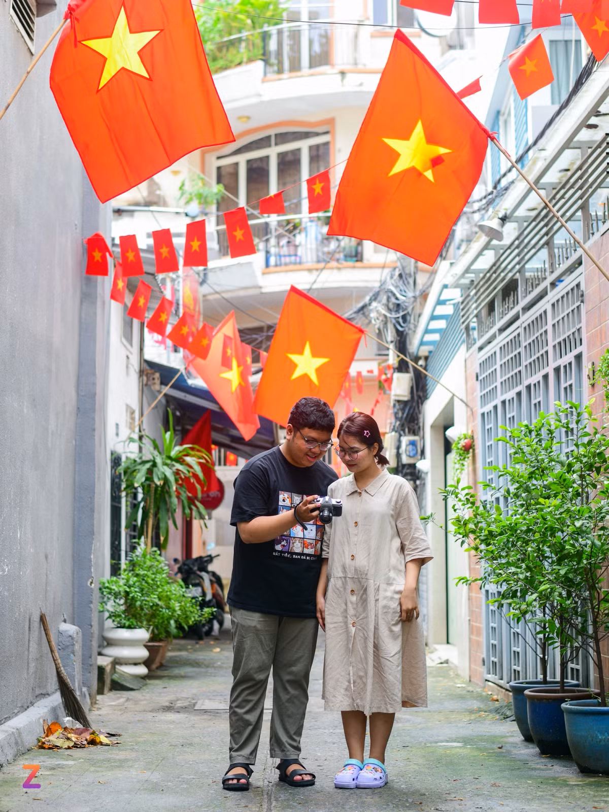 Không có kế hoạch đi chơi xa trong 4 ngày nghỉ lễ, Huyền Trang cùng bạn dạo quanh thành phố, tìm kiếm những địa điểm có trang trí quốc kỳ để chụp ảnh. "Tôi xem review thì thấy trên đường Trần Hưng Đạo (quận 1) có một con hẻm nhỏ treo cờ rất đẹp nên cả 2 quyết định đi tìm. Người dân trang trí rất khéo, những dây cờ nhỏ đan xen với lá cờ lớn trông rất ấn tượng", Trang chia sẻ.