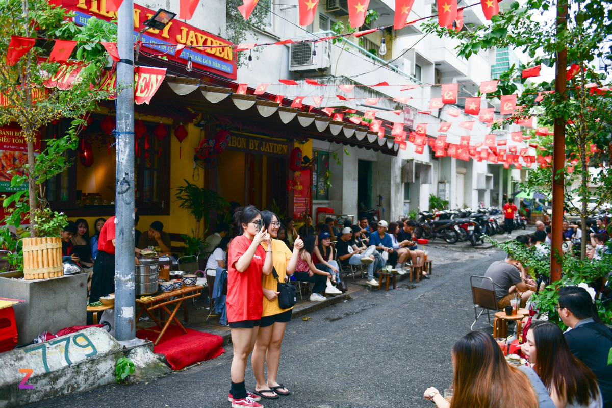 Khu vực xung quanh chung cư 10A Trần Nhật Duật (quận 1) thu hút đông đúc giới trẻ TP.HCM tìm đến uống cà phê, chụp ảnh vì các hàng quán tại đây đồng loạt trang trí bằng những dây cờ đỏ sao vàng.