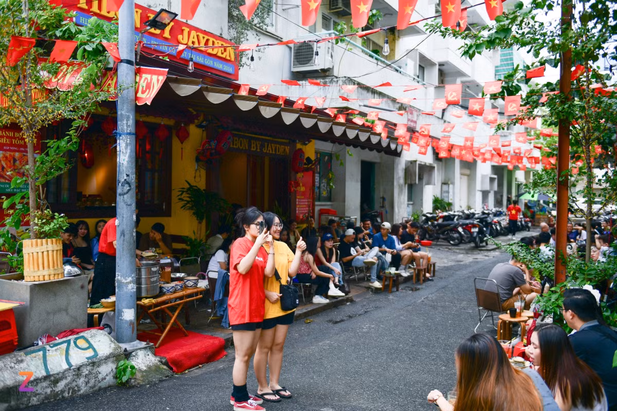 Khu vực xung quanh chung cư 10A Trần Nhật Duật (quận 1) thu hút đông đúc giới trẻ TP.HCM tìm đến uống cà phê, chụp ảnh vì các hàng quán tại đây đồng loạt trang trí bằng những dây cờ đỏ sao vàng.