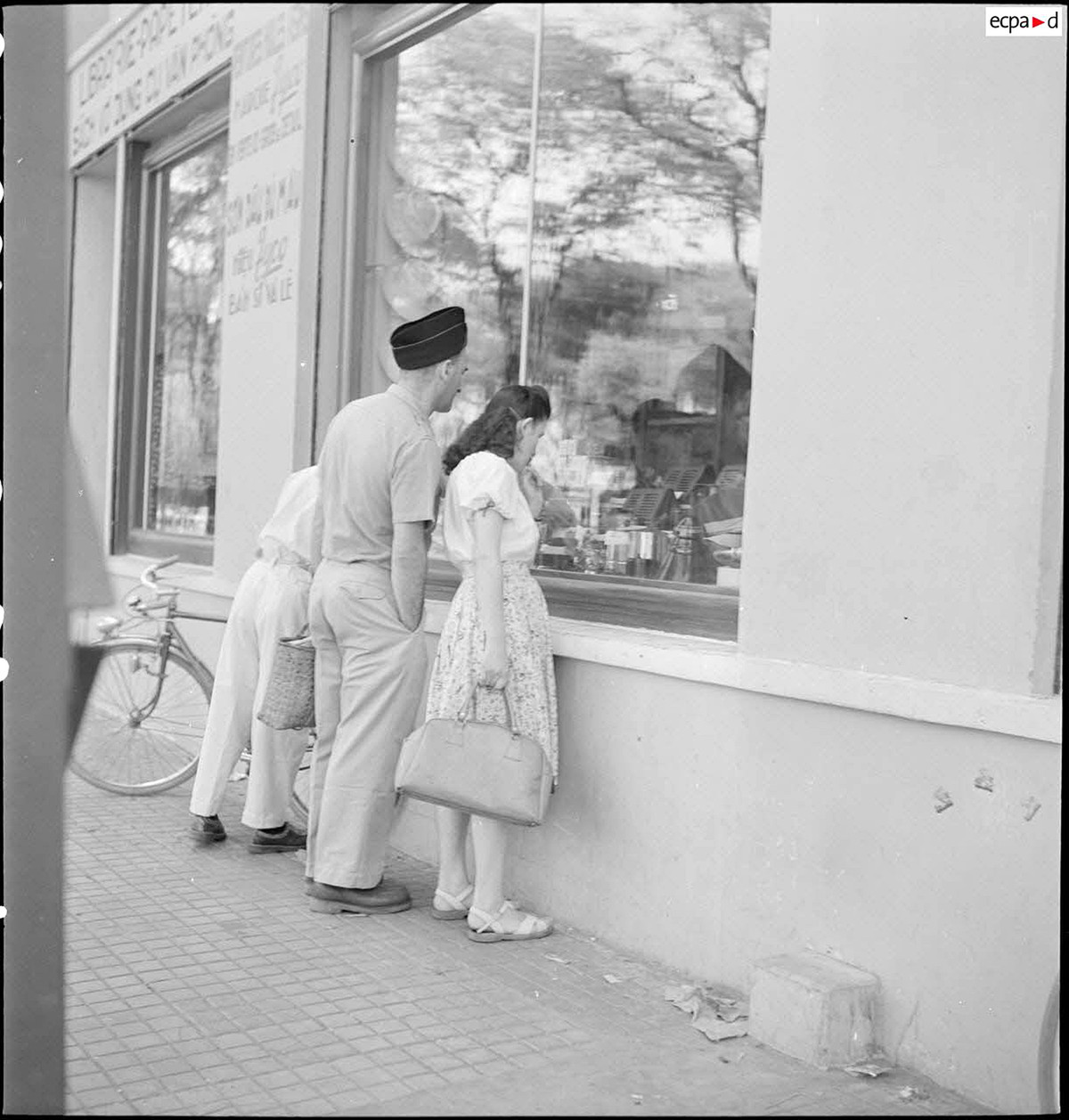 Người nước ngoài cũng bị thu hút bởi các hàng hóa được trưng bày bắt mắt. Ảnh: Auteur inconnu/ECPAD/Défense.