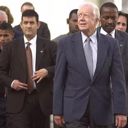 Trong hình, cựu tổng thống Jimmy Carter được đội ngũ an ninh bảo vệ cẩn thận.