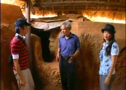 Ông Liên (giữa) đang giới thiệu "làng chiến tranh" với du khách.