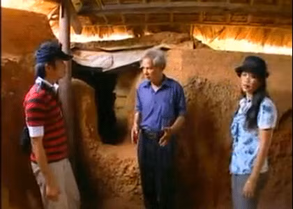 Ông Liên (giữa) đang giới thiệu "làng chiến tranh" với du khách.