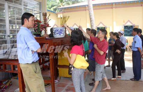 Du khách thắp hương tại nhà mồ.