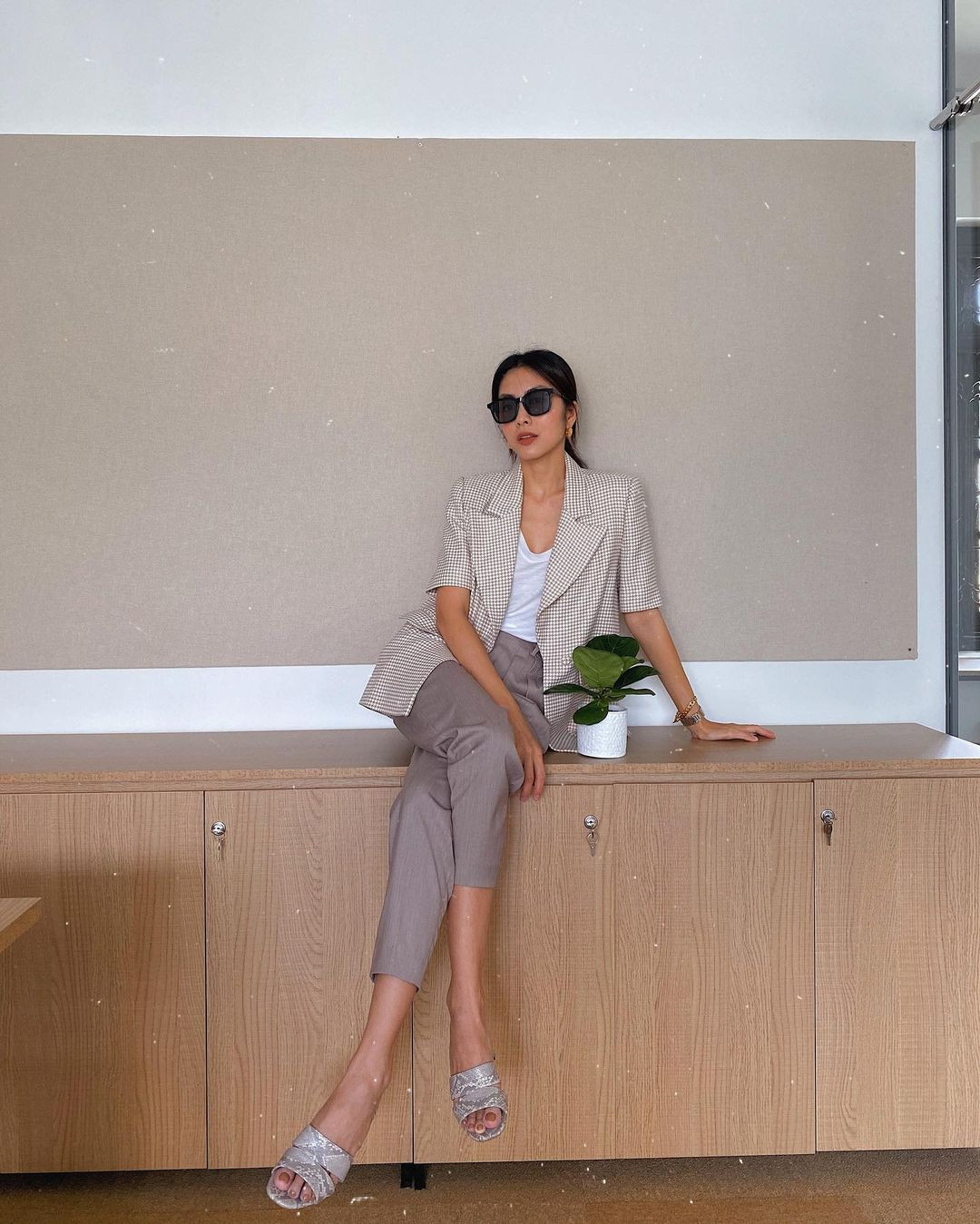 Trong những ngày thời tiết không quá nóng thì Hà Tăng lại chọn diện blazer cộc tay mix với áo phông và quần âu dáng thuốc lá. Kiểu blazer với tay áo ngắn mang đến cho cô vẻ thanh lịch chỉn chu mà vẫn có nét phá cách thú vị. Về phần giày dép thì một đôi dép bệt mang tông màu tối giản sẽ là sự lựa chọn hợp lý. Cuối cùng đừng quên tô điểm style với một đôi khuyên tai nhỏ xinh