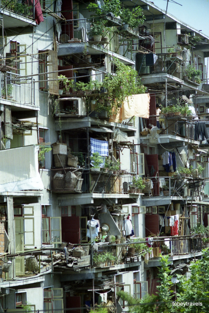 Cổng khách sạn Giang Hán (trái) và những ban công của một chung cư (phải).