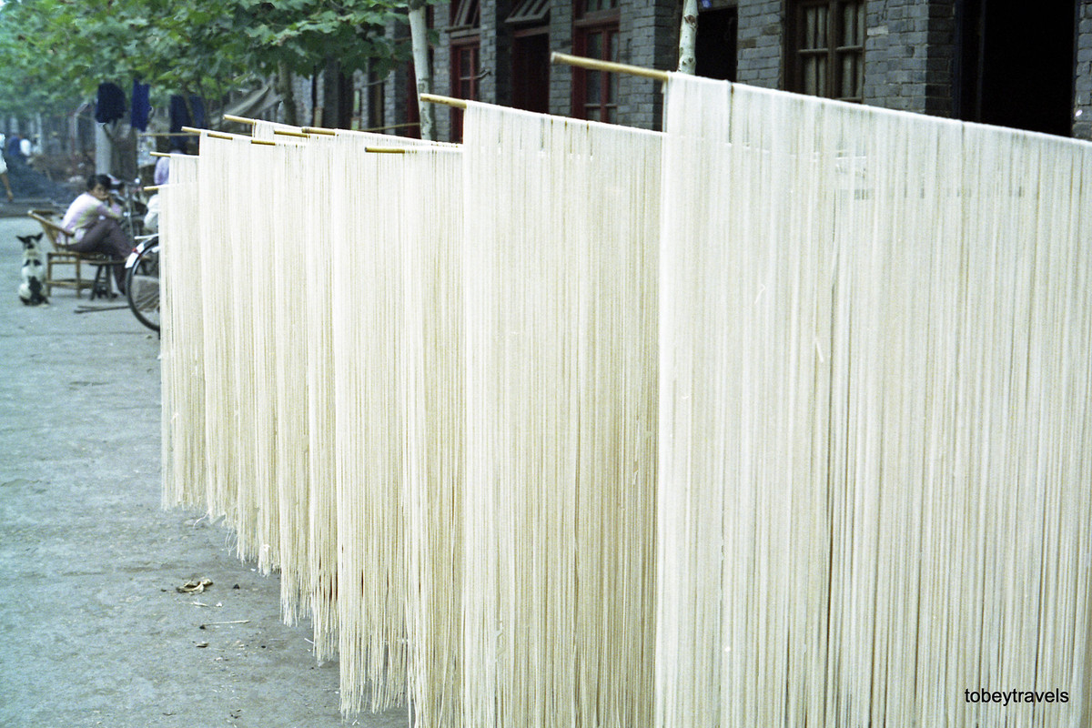 Mì làm thủ công được phơi trên sào tre bên ngoài một ngôi nhà.