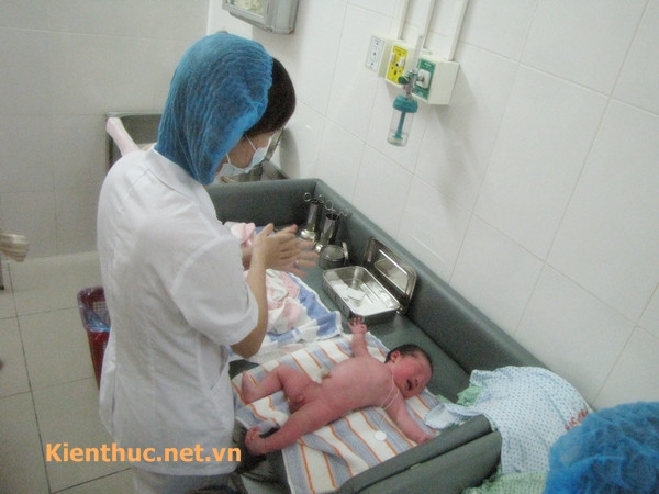 sau đó hộ sinh sẽ rửa sạch và sát trùng tay để làm rốn cho bé.