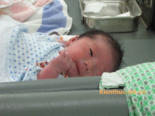 Em bé thư giãn khi được chăm sóc rốn