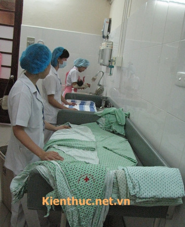 Các nữ hộ sinh đứng ở khu vực bàn của mình để đón bé