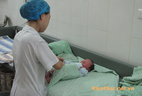 Sau khi mặc áo, làm rốn, em bé sẽ được hộ sinh thứ 3 quấn tã sạch
