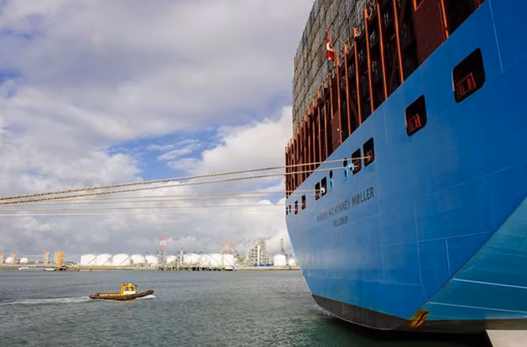 Một con thuyền nhỏ đang đến gần tàu Maersk Mc-Kinney Moeller khi tàu này đang xếp hàng ở cảng Rotterdam.