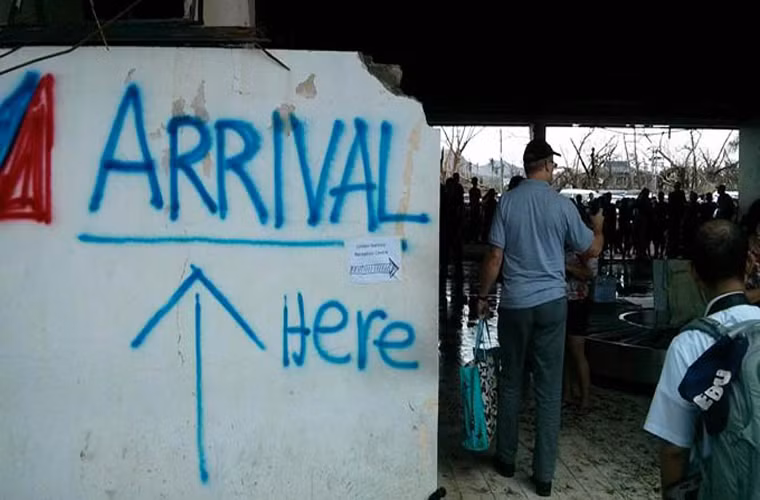 Sân bay Daniel Z. Romualdez của Tacloban bị bão phá hoại. Khu vực khách đến được đánh dấu bằng một tấm biển báo thô sơ như thế này.