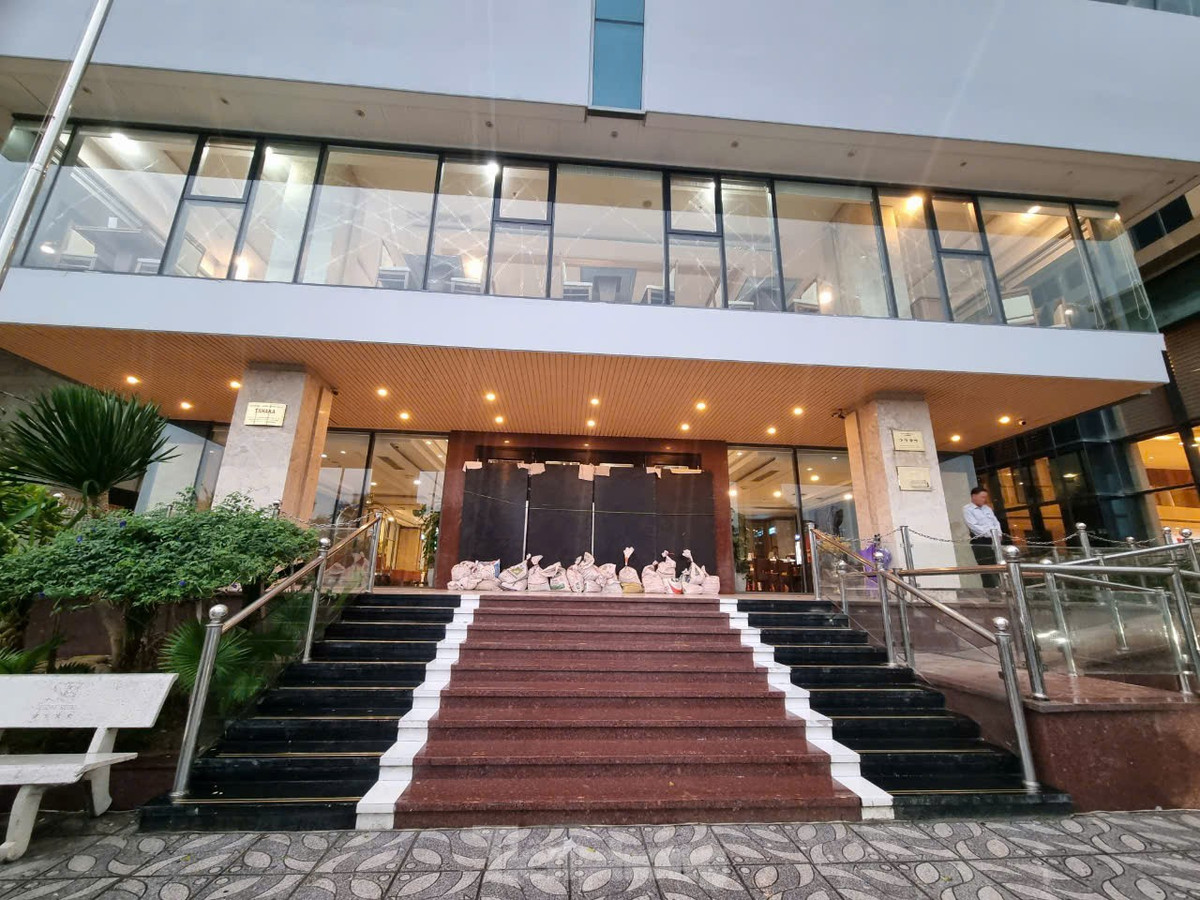 Để tránh bị gió giật mạnh, ngoài dùng các tấm chắn, các khách sạn còn chèn bao cát phía dưới để giữ cửa chắc hơn.