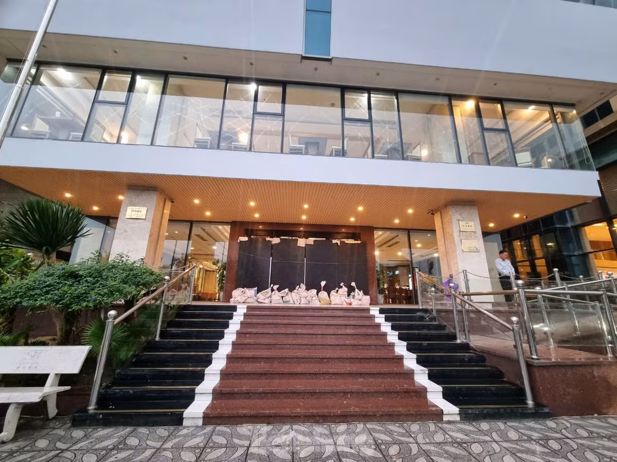 Để tránh bị gió giật mạnh, ngoài dùng các tấm chắn, các khách sạn còn chèn bao cát phía dưới để giữ cửa chắc hơn.