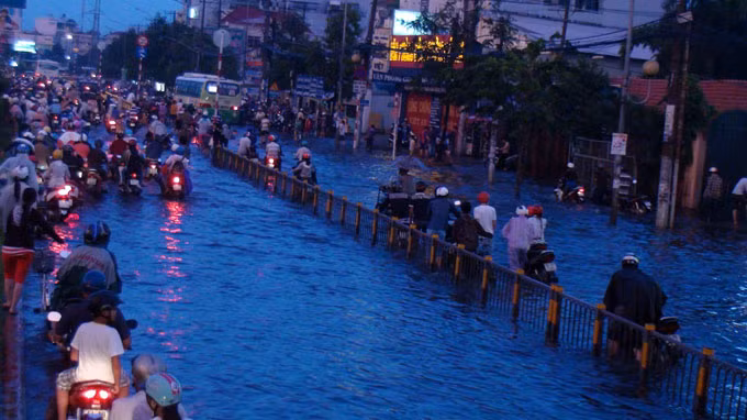 Còn tại đường Kinh Dương Vương đoạn ở P.An Lạc, Q.Bình Tân, nước ngập đến đầu gối khiến hàng ngàn xe cộ băng qua đoạn đường này bị chết máy. Mỗi khi ôtô chạy qua, từng đợt sóng nước dâng lên xô ngã người đi đường.