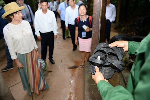 Nhân viên địa đạo Củ Chi giới thiệu cách làm dép cao su cho phu nhân Tổng thống. Ảnh: Thuận Thắng.