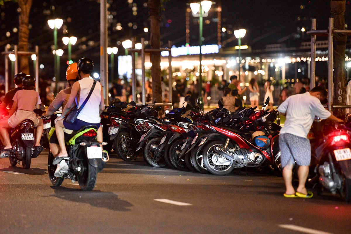 Một số khu vực lề đường còn được trưng dụng làm chỗ gửi xe. Thay vì dựng sát vỉa hè, người trông xe quay ngang xe máy và xếp san sát nhau.