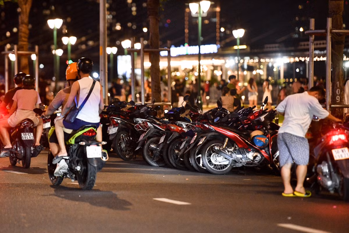 Một số khu vực lề đường còn được trưng dụng làm chỗ gửi xe. Thay vì dựng sát vỉa hè, người trông xe quay ngang xe máy và xếp san sát nhau.