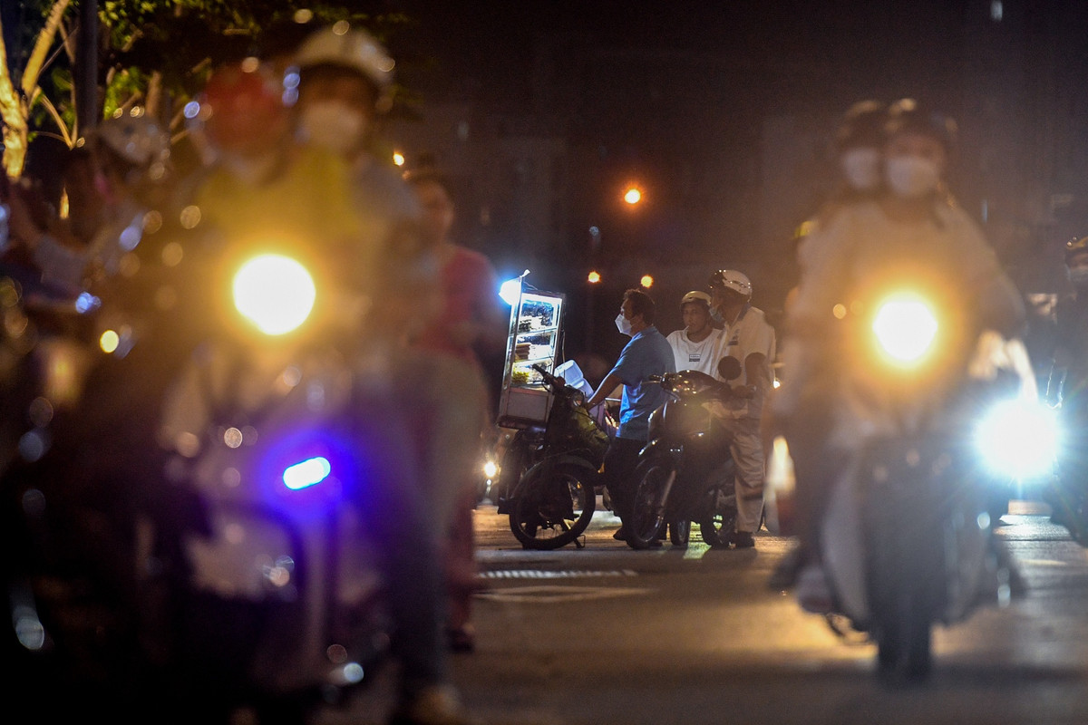 Một chiếc xe bán đồ ăn vặt đỗ lấn ra gần giữa đường. Các phương tiện di chuyển trên đường Tôn Đức Thắng phải chủ động né người này.