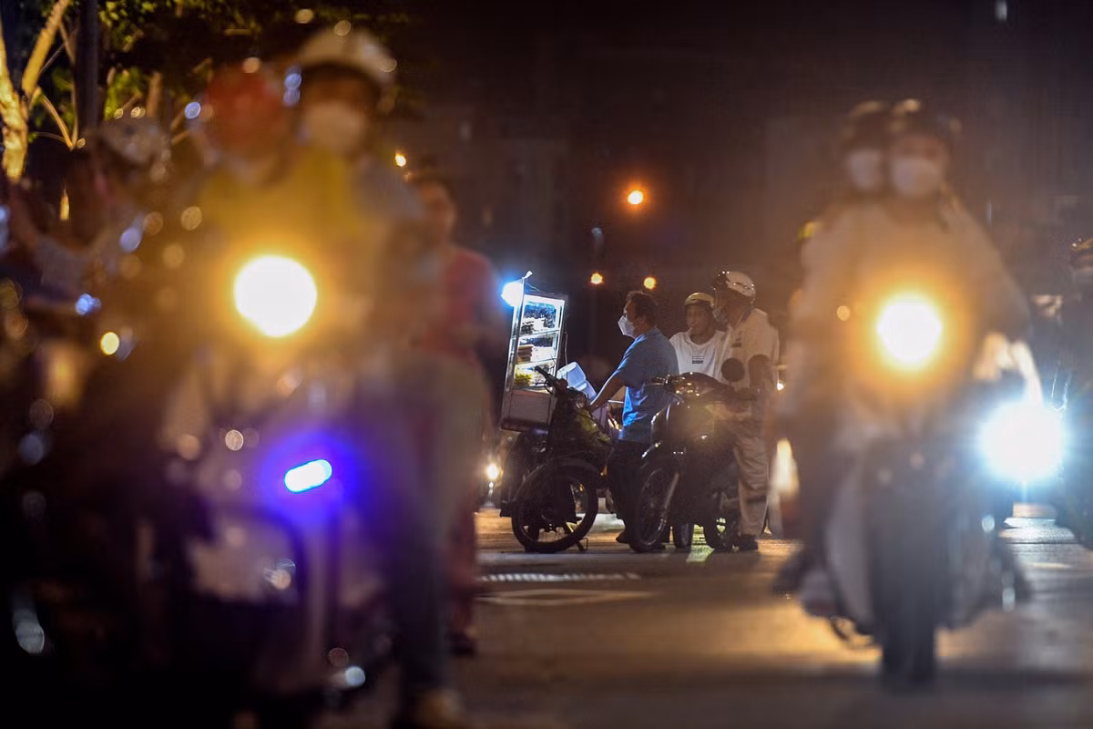 Một chiếc xe bán đồ ăn vặt đỗ lấn ra gần giữa đường. Các phương tiện di chuyển trên đường Tôn Đức Thắng phải chủ động né người này.