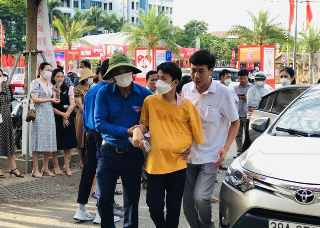 Một thí sinh được các tình nguyện viên hỗ trợ vào phòng thi.