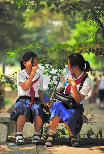 Hai nữ sinh Triều Tiên ngồi trên ghế đá vui đùa cùng nhau.