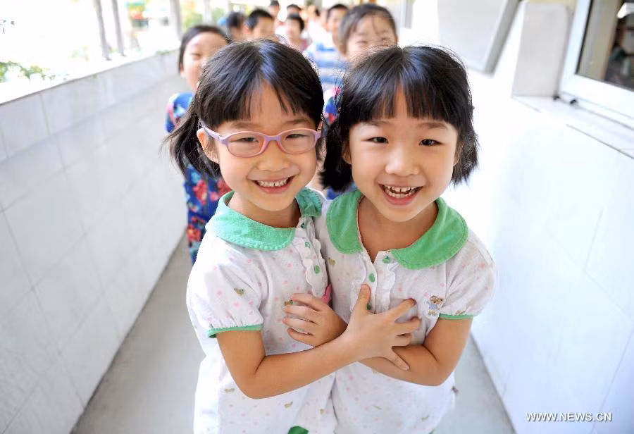 Cặp song sinh Shan Xinyue và Shan Xinyi rạng rỡ bước vào lớp 1 trong lễ khai giảng hôm qua, chủ nhật (1/9) tại trường tiểu học Đường Zhong Yang ở Nam Kinh, Giang Tô, phía đông Trung Quốc.