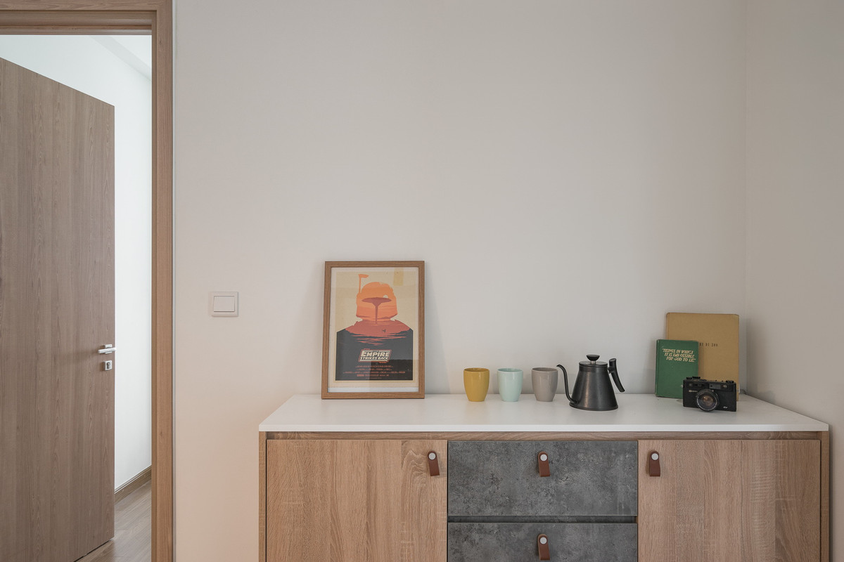 Tủ trang trí trưng bày ly, tách và chậu cây nhỏ. Nội thất phòng khách mang đường nét đơn giản nhưng đầy ấm cúng.